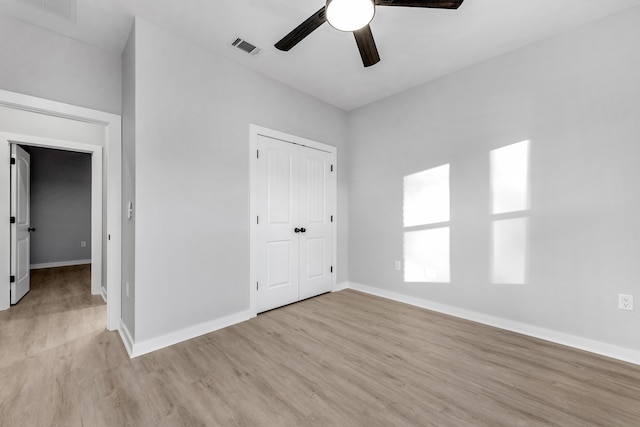 unfurnished bedroom featuring ceiling fan, a closet, and light hardwood / wood-style flooring