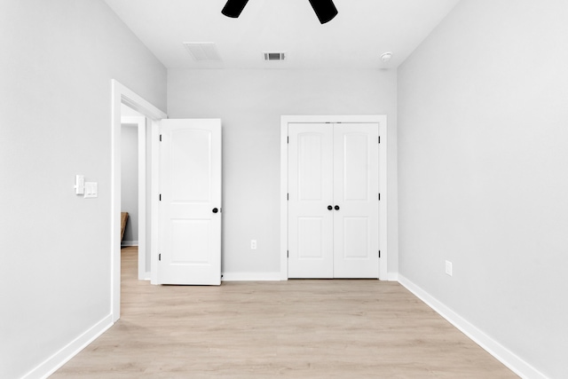 unfurnished bedroom with light hardwood / wood-style flooring, a closet, and ceiling fan