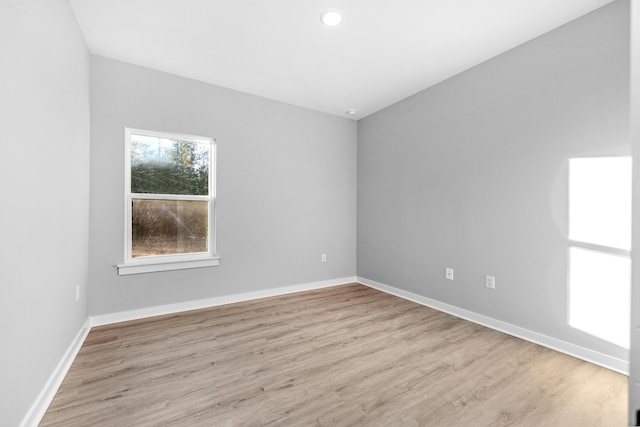 spare room with recessed lighting, baseboards, and wood finished floors