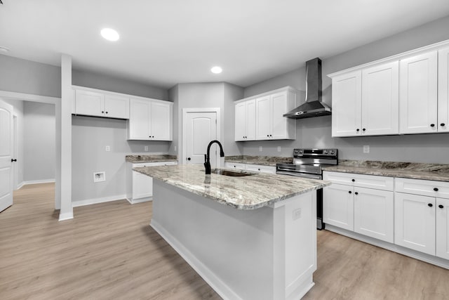 kitchen with sink, white cabinets, light stone counters, a center island with sink, and wall chimney exhaust hood