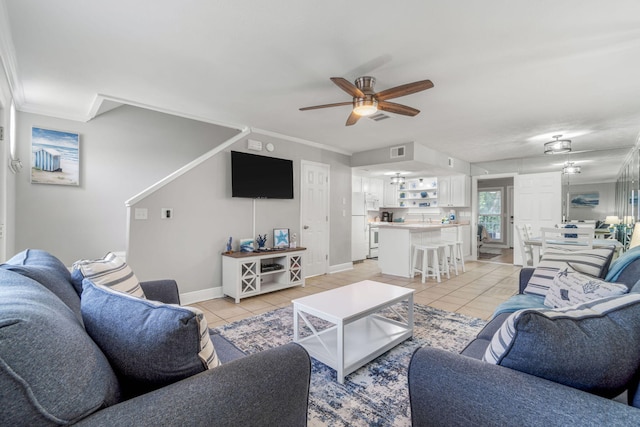 living room featuring ornamental molding, light tile patterned floors, and ceiling fan