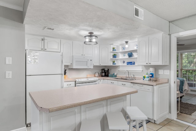 kitchen featuring sink, white appliances, a breakfast bar area, and white cabinets