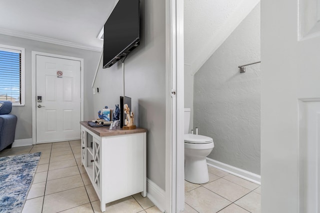 interior space featuring tile patterned flooring, crown molding, and toilet