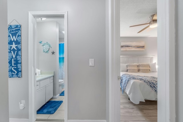 tiled bedroom featuring sink, a textured ceiling, and ensuite bathroom