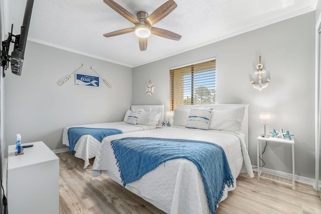 bedroom with ceiling fan, ornamental molding, a textured ceiling, and light wood-type flooring