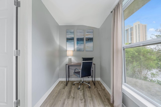 home office featuring lofted ceiling and light hardwood / wood-style floors