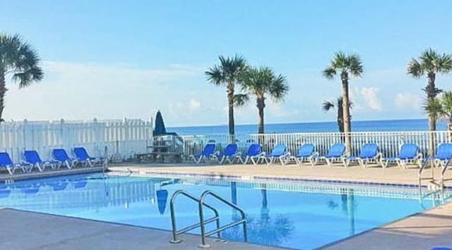 view of swimming pool with a water view and a patio area