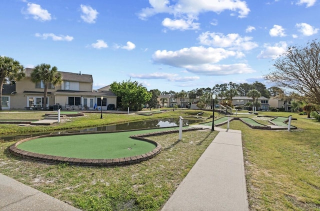 view of home's community featuring a water view and a lawn