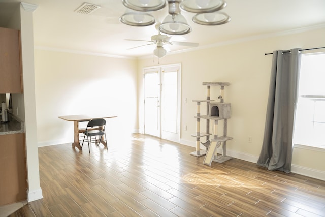 dining area with wood-type flooring, a wealth of natural light, ceiling fan, and crown molding