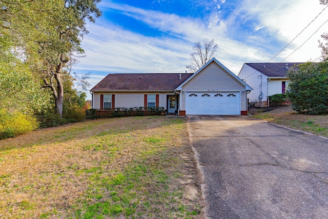 ranch-style home featuring an attached garage, concrete driveway, and a front yard