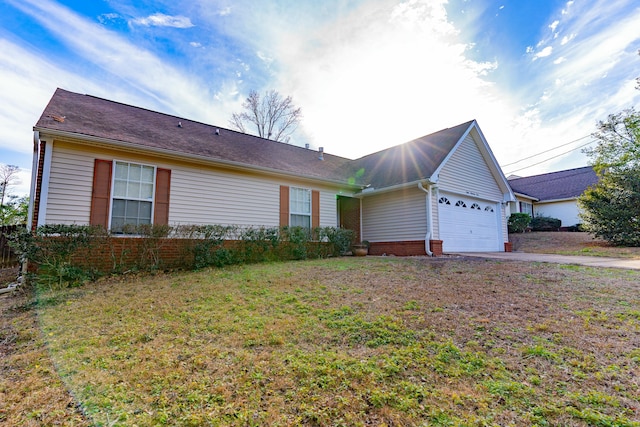 ranch-style house featuring an attached garage, driveway, and a front lawn