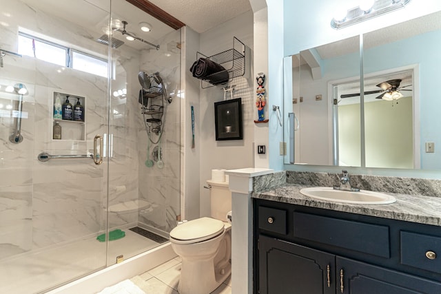 bathroom with a stall shower, toilet, ceiling fan, a textured ceiling, and vanity