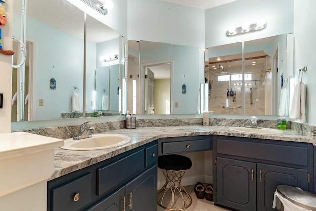 full bathroom featuring double vanity, a sink, and a shower stall