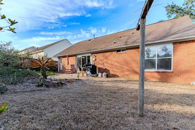 back of house featuring brick siding and a shingled roof