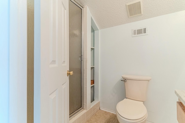 bathroom featuring a stall shower, visible vents, a textured ceiling, and toilet