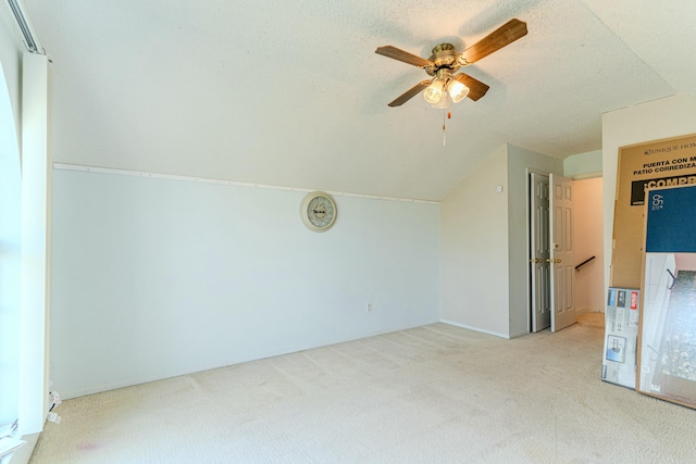 bonus room featuring light carpet, a textured ceiling, lofted ceiling, and a ceiling fan