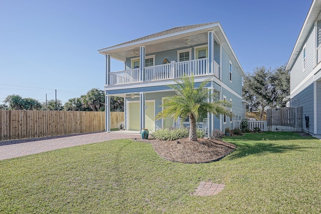 back of property with a garage, a balcony, and a yard