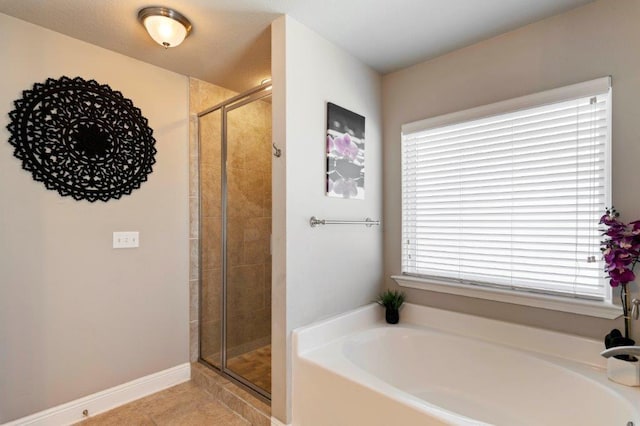 bathroom with tile patterned floors and shower with separate bathtub