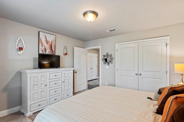 carpeted bedroom featuring a closet and a textured ceiling