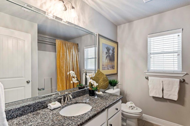 bathroom with vanity, tile patterned flooring, and toilet