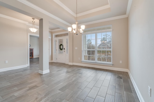 unfurnished dining area with a raised ceiling, ornamental molding, and light wood-type flooring