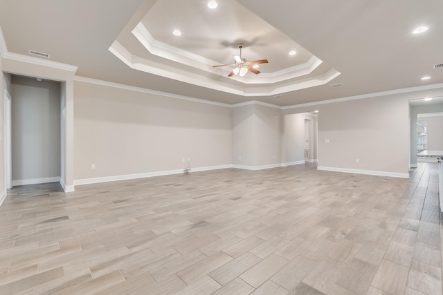 spare room featuring a raised ceiling, crown molding, ceiling fan, and light hardwood / wood-style flooring