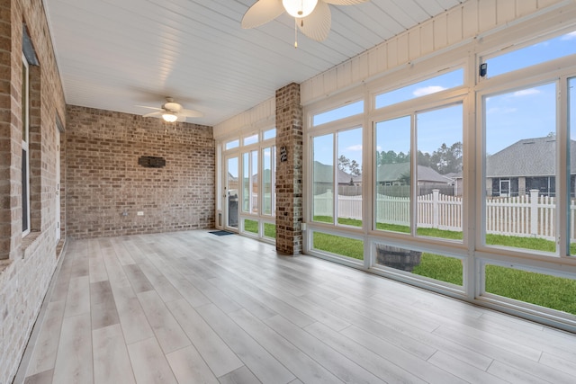 unfurnished sunroom with ceiling fan