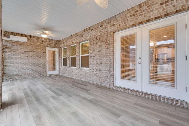 unfurnished sunroom featuring french doors and ceiling fan