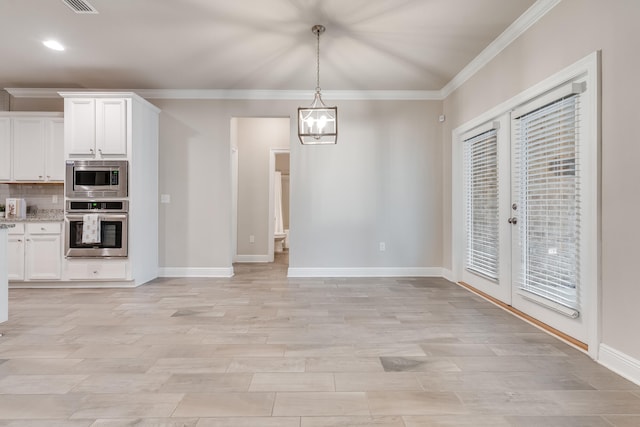 unfurnished dining area with french doors, a notable chandelier, ornamental molding, and light wood-type flooring