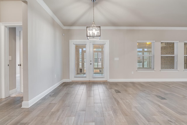 foyer with lofted ceiling, light hardwood / wood-style flooring, a chandelier, ornamental molding, and french doors