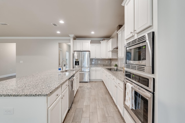 kitchen featuring a kitchen island with sink, sink, white cabinetry, and stainless steel appliances