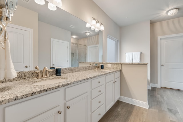 bathroom featuring hardwood / wood-style flooring, vanity, and an enclosed shower