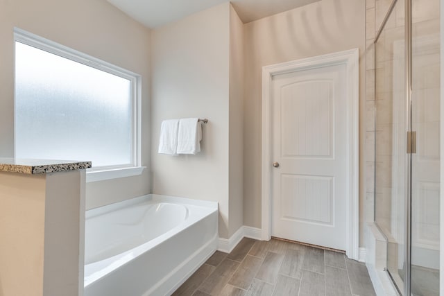 bathroom featuring shower with separate bathtub