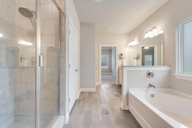 bathroom featuring vanity, hardwood / wood-style flooring, and separate shower and tub