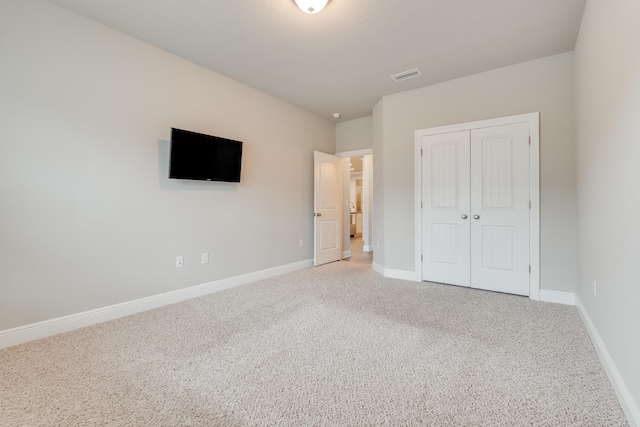 unfurnished bedroom featuring carpet floors and a closet