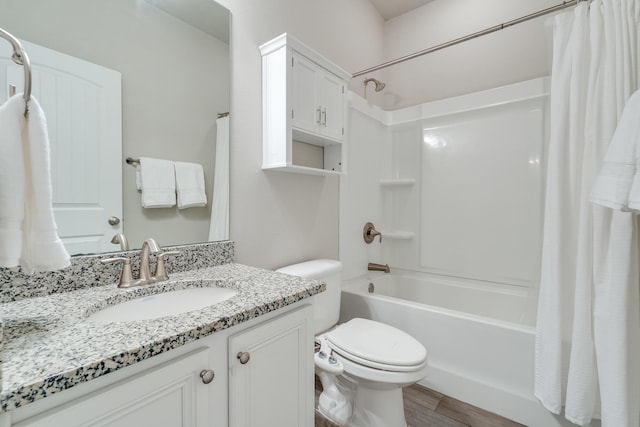 full bathroom with hardwood / wood-style flooring, vanity, shower / bathtub combination with curtain, and toilet