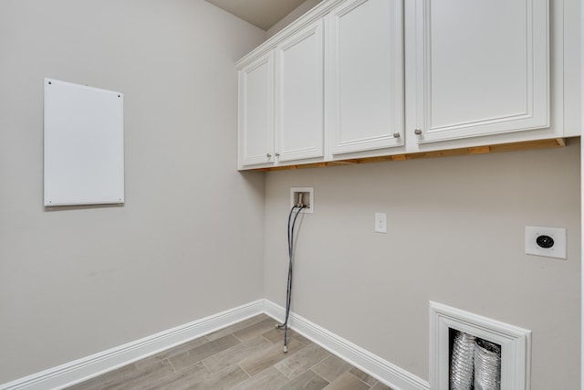 clothes washing area with cabinets, hookup for an electric dryer, hookup for a washing machine, and light hardwood / wood-style flooring