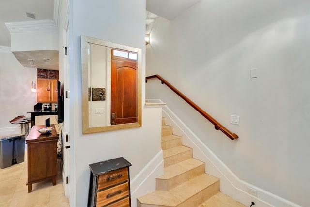 stairway with crown molding and tile patterned floors