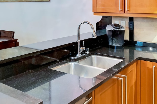 kitchen featuring dark stone countertops and sink