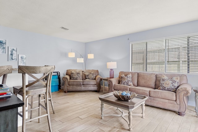 living room with light hardwood / wood-style floors and a textured ceiling