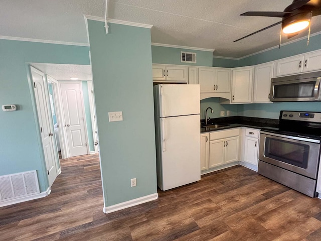 kitchen with white cabinetry, sink, stainless steel appliances, and dark hardwood / wood-style floors