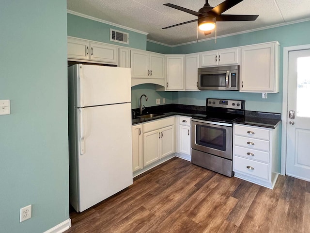 kitchen featuring dark wood-type flooring, sink, white cabinetry, ornamental molding, and appliances with stainless steel finishes