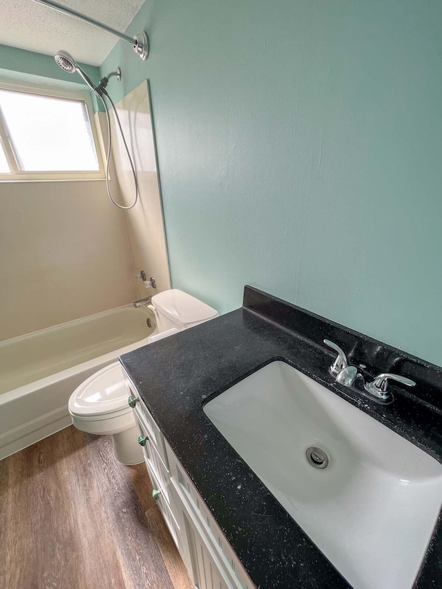 full bathroom featuring washtub / shower combination, vanity, toilet, and wood-type flooring