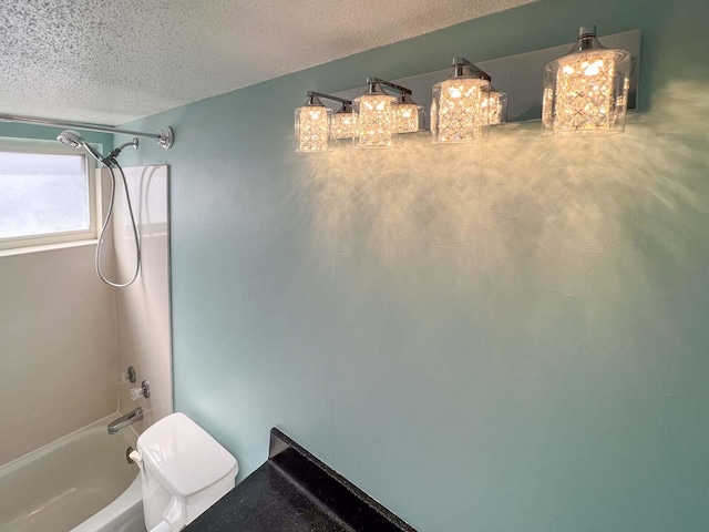 bathroom with a textured ceiling, shower / bathtub combination, and toilet