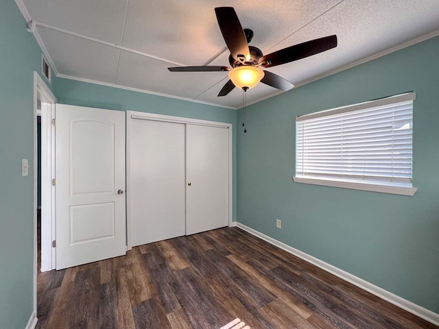 unfurnished bedroom with ornamental molding, dark hardwood / wood-style flooring, and a closet