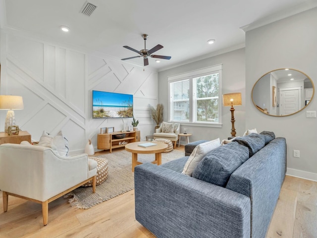 living area with a ceiling fan, baseboards, visible vents, light wood-style floors, and ornamental molding