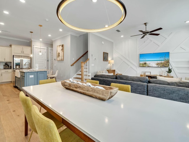 interior space featuring ornamental molding, recessed lighting, stairway, and light wood finished floors