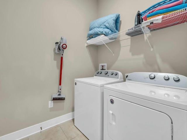 laundry room featuring laundry area, washer and clothes dryer, light tile patterned flooring, and baseboards