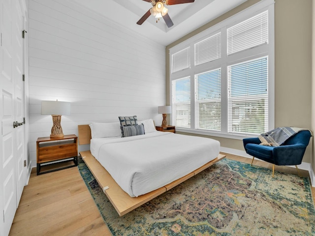 bedroom with ceiling fan, baseboards, and light wood-style floors