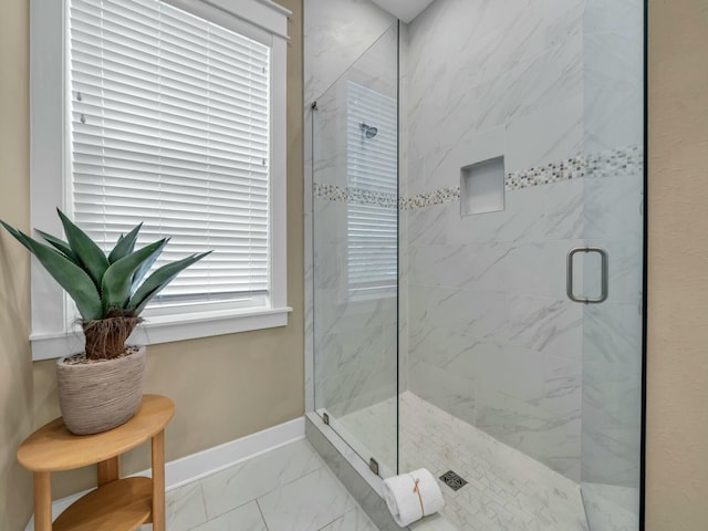 full bathroom with marble finish floor, a marble finish shower, and baseboards